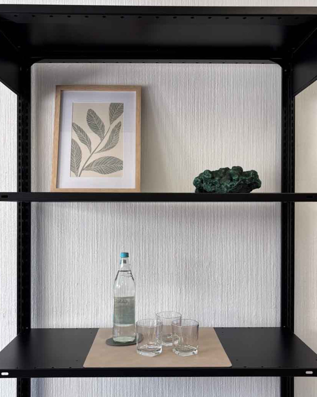 Beige Design-Unterlage 43x38,5 cm aus recyceltem Leder auf einem schwarzen Design-Regal mit Flasche und Gläsern