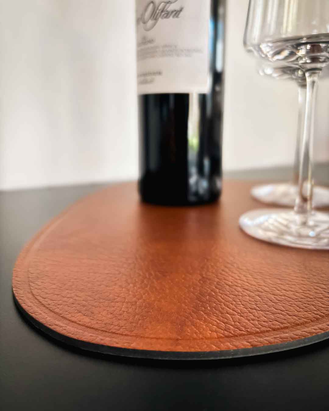 MATS braune Design-Unterlage aus recyceltem Leder auf einem Design-Regal aus Stahl mit Weinflasche und Gläsern