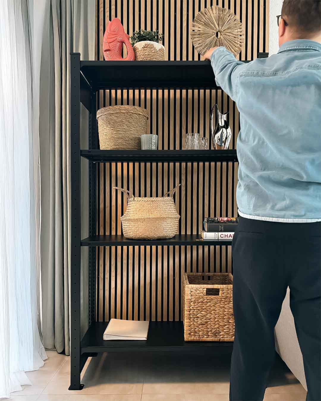 Schwarzes MICA Design Standregal aus Stahl mit 180 cm Höhe im Wohnraum mit Person in Anwendung