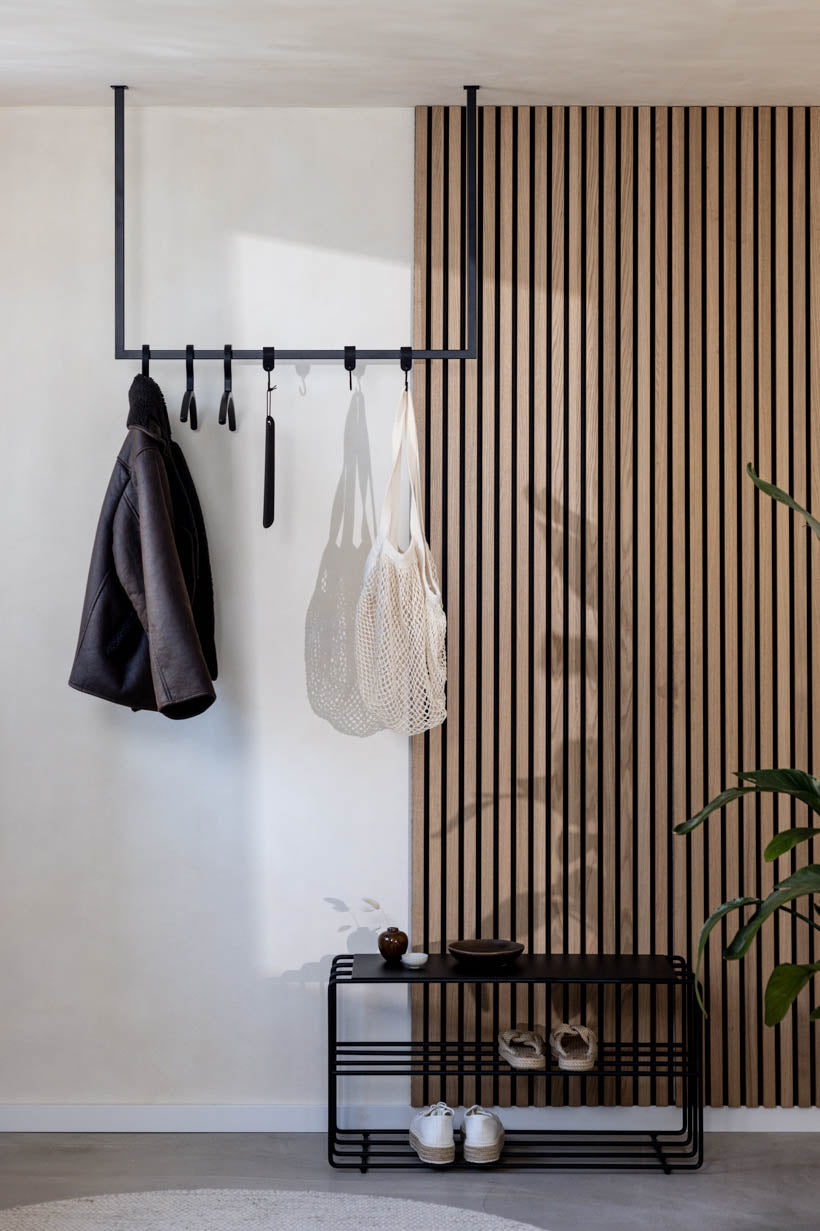 Schwarze RUBI Garderobenstange im Flur mit aufgehängter Kleidung