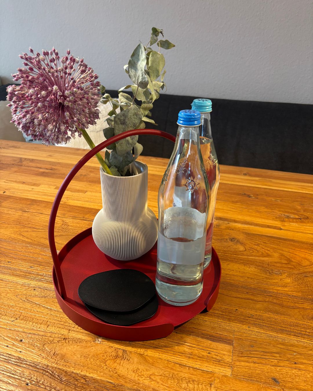 Bundle aus Designvase PURE, Untersetzer KIVA und Serviertablett ARCO in Rot auf Holztisch