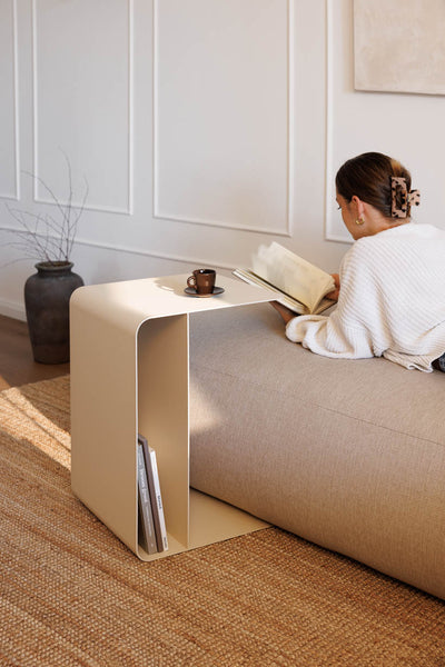 Beiger Beistelltisch COSMO am Sofa mit Tasse und Buch in Anwendung