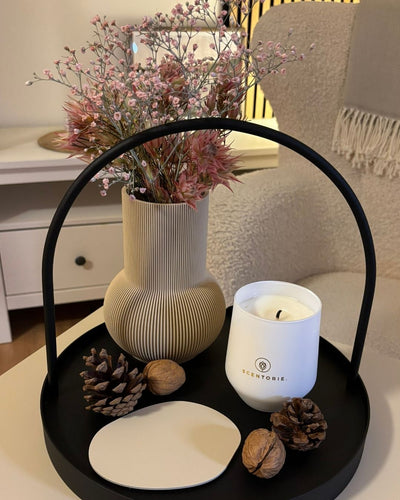 Duftkerze mit Untersetzern und Designvase auf Serviertablett