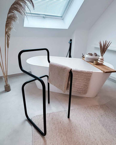 Schwarzer Herrendiener JAMES im Badezimmer vor einer Badewanne mit Handtuch