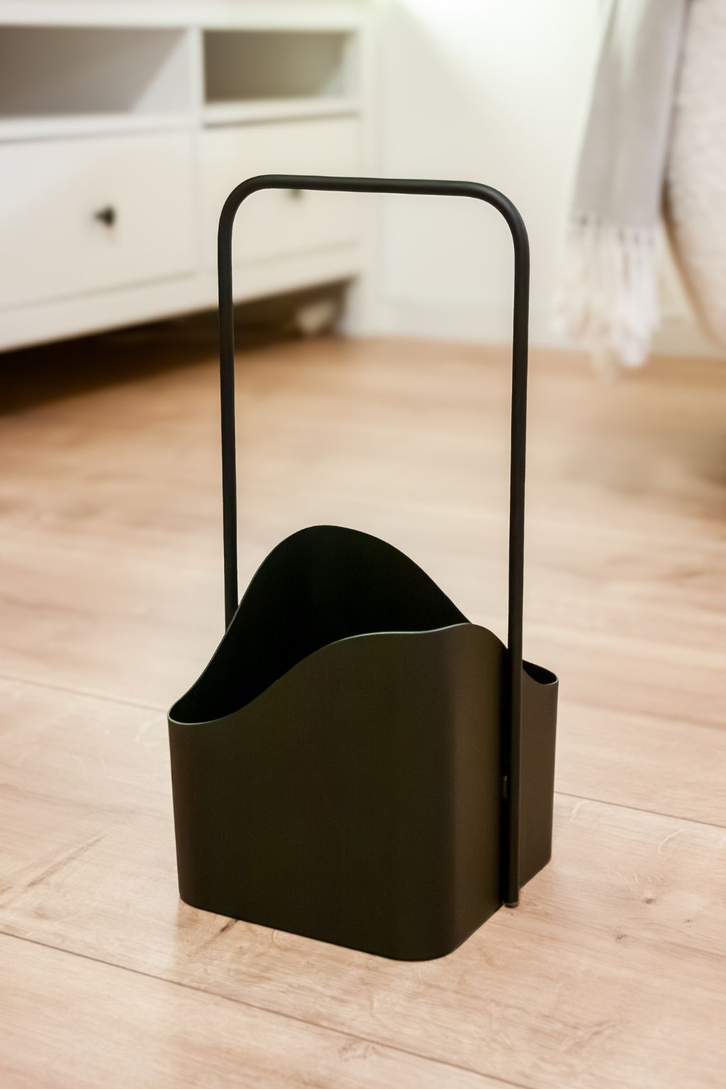 LUNO Aufbewahrungskorb aus schwarzem Stahl mit Griff als moderne Ordnungslösung im Wohnzimmer