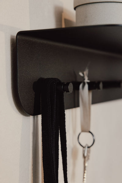 Detailaufnahme der schwarzen MALOU Wandgarderobe mit Ablage und Haken