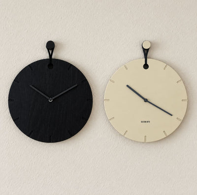 Wanduhren Big Hug in Beige und Schwarz an Wand hängend