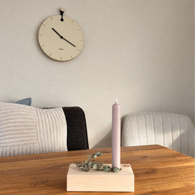 Wanduhr Big Hug in Beige im Wohnzimmer hängend